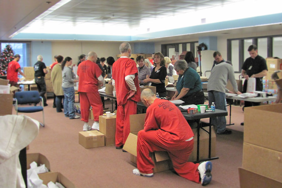 Volunteers and incarcerated individuals assembling packages