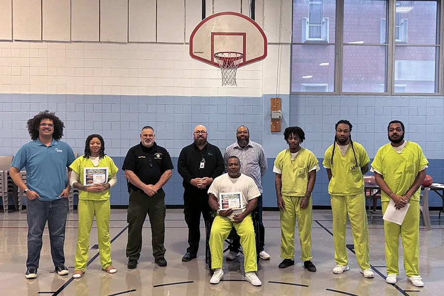 Group of individuals at a basketball court holding certificates