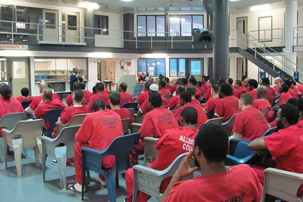 Incarcerated men in assembly with speaker presenting