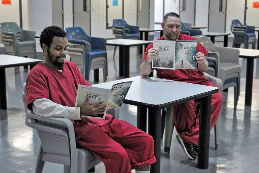 Two individuals reading at a table in a pod